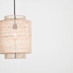 Een stijlvolle hanglamp van natuurlijke vezels in een warm ingericht salon, perfect voor een gezellige sfeer.